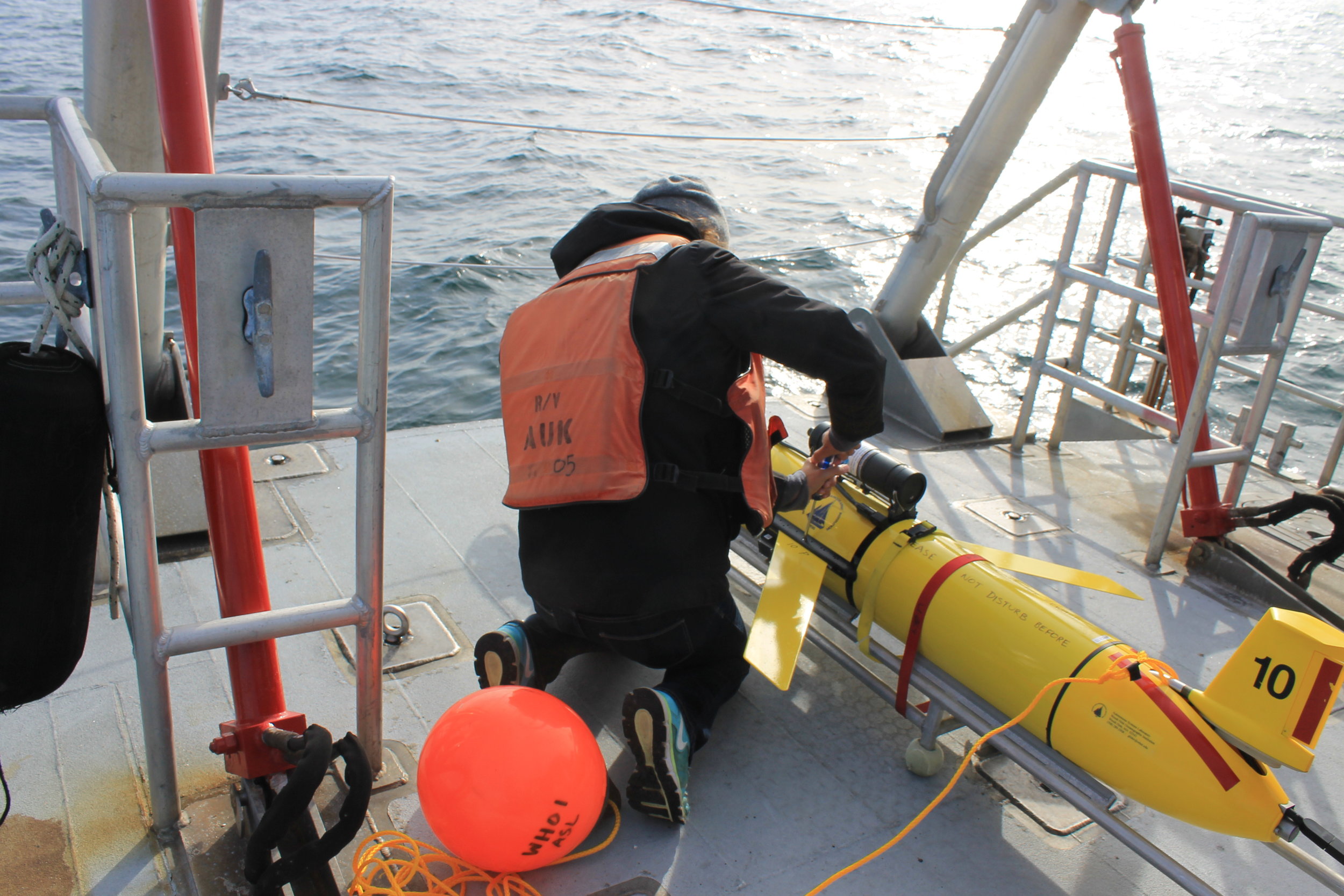 A researcher aboard the Auk prepares a Slocum glider to launch. © Claudia Geib.