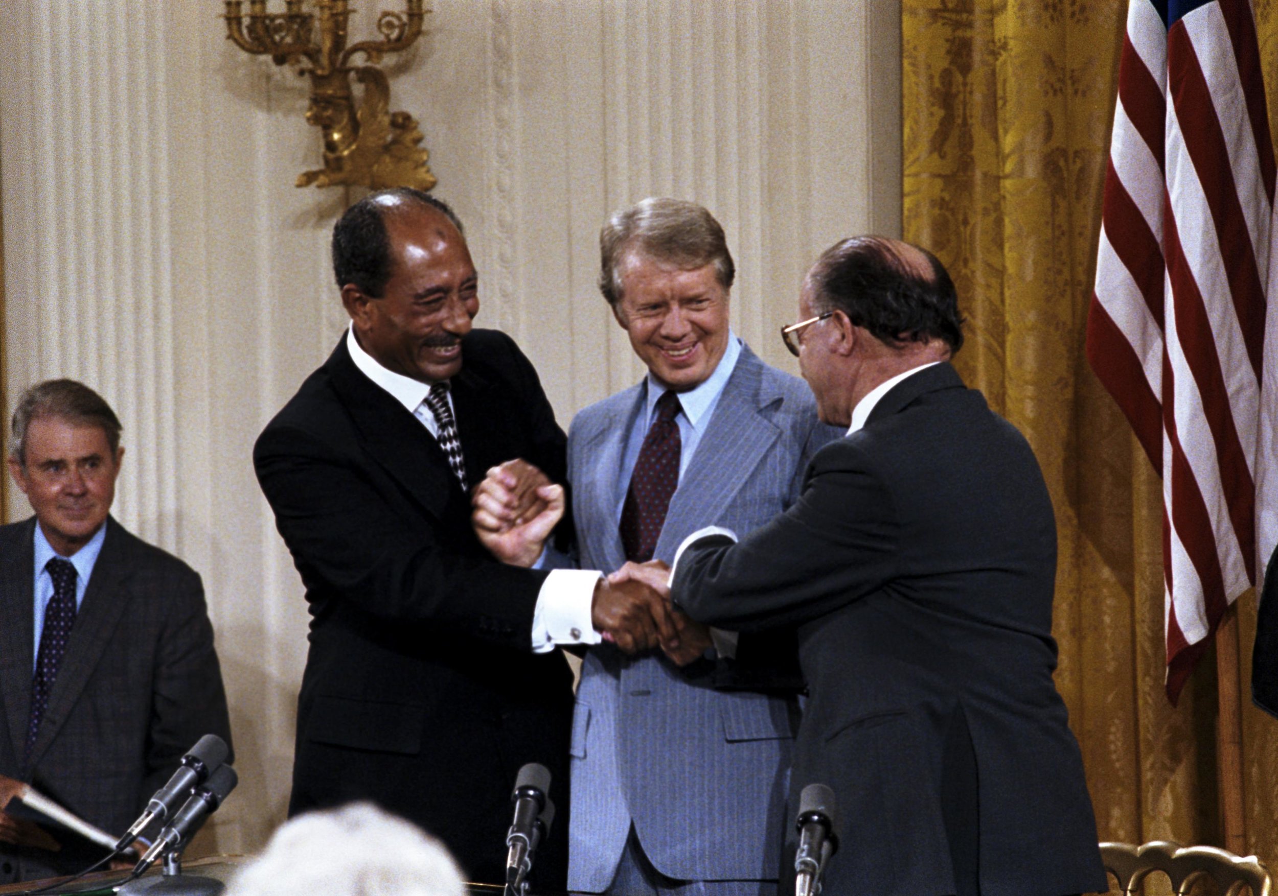 Triple handshake with Carter, Sadat, and Begin in the East Room, September 17, 1978. Depending on their culture, some of the men in this picture may have been comfortable with the nearness than others. CIA/Wikimedia Commons (public domain)