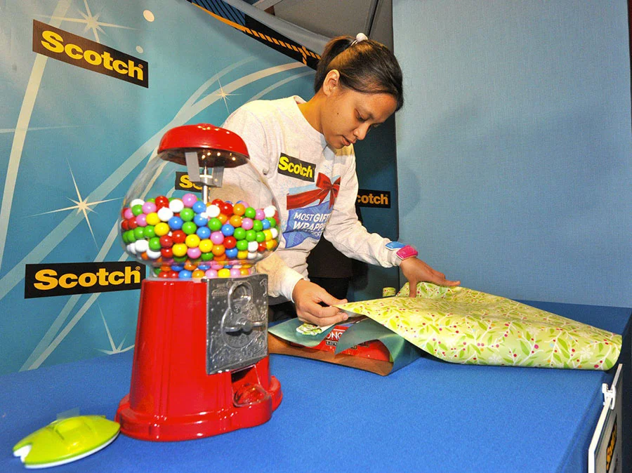 Diana wraps a giant gum ball machine at the 2011 Scotch Brand Most Gifted Wrapper Contest. Photo courtesy of Scotch™ Brand ( http://www.scotchbrand.com/3M/en_US/scotch-brand/ ): photographed by Ray Stubblebine (INSIDER IMAGES)