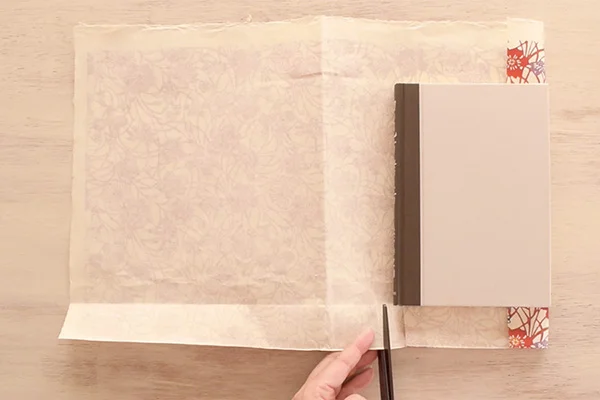 Step 4: Place your book along the folds, then cut two slits at the thickness of the book.
