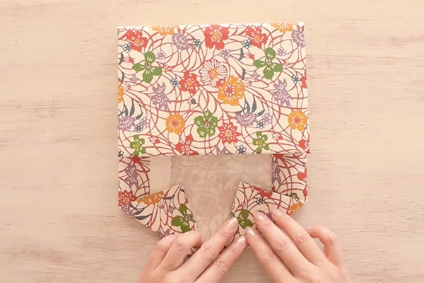 Step 15: Continue to fold the sides in triangles to create an envelope flap.