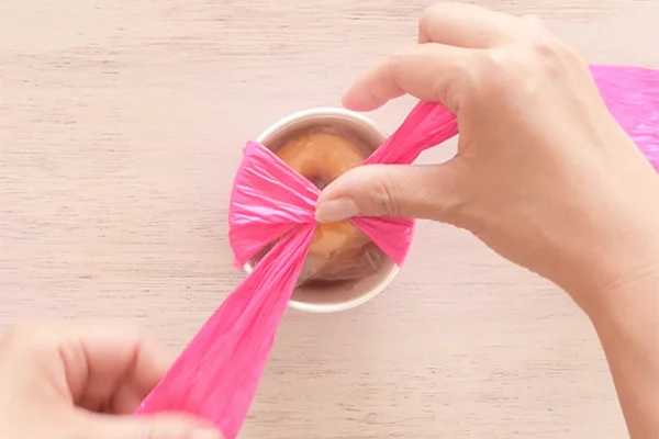 Step 7: Wrap the paper ribbon around the cup vertically, then cross at the top.
