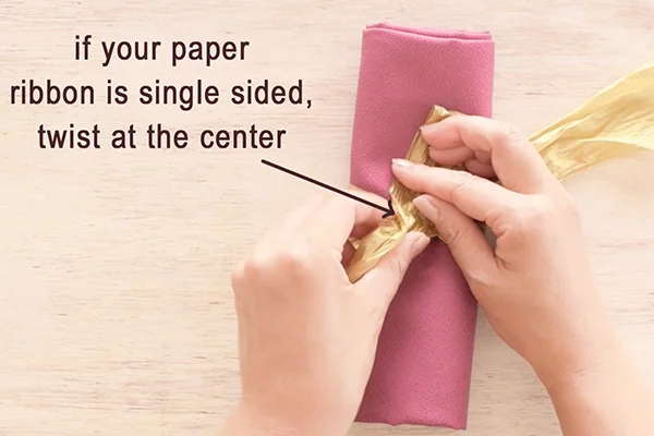 Step 4: Twist at the center if your paper ribbon is single sided, to show the front side ribbon. Skip this step if you're using double sided ribbon.
