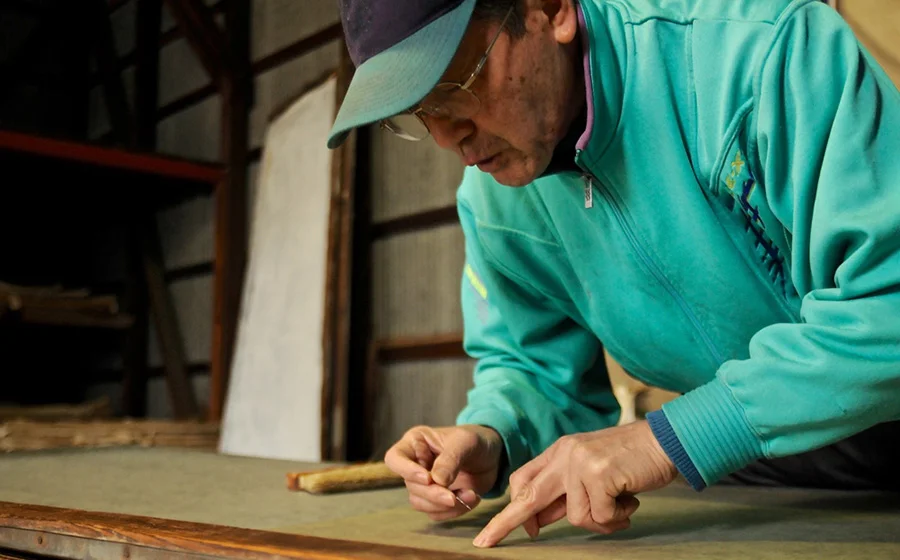 Mr. Uda removes any dust or unwanted parts using the tip of the needle. (Photo by Yoko Takahashi)