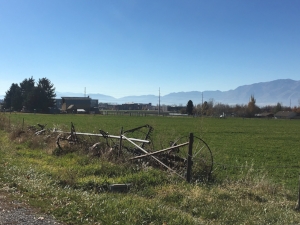 Farmland and equipment in the front, barn behind, then some university buildings where they do space research in the back. 