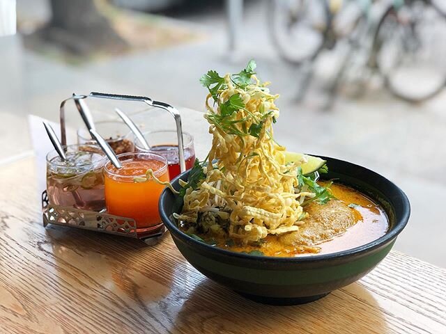 Khao soi - Northern Thai coconut curry noodle soup with chicken leg. Served with flat egg noodles and crispy noodles on top OR try it with any other noodles we have in house!