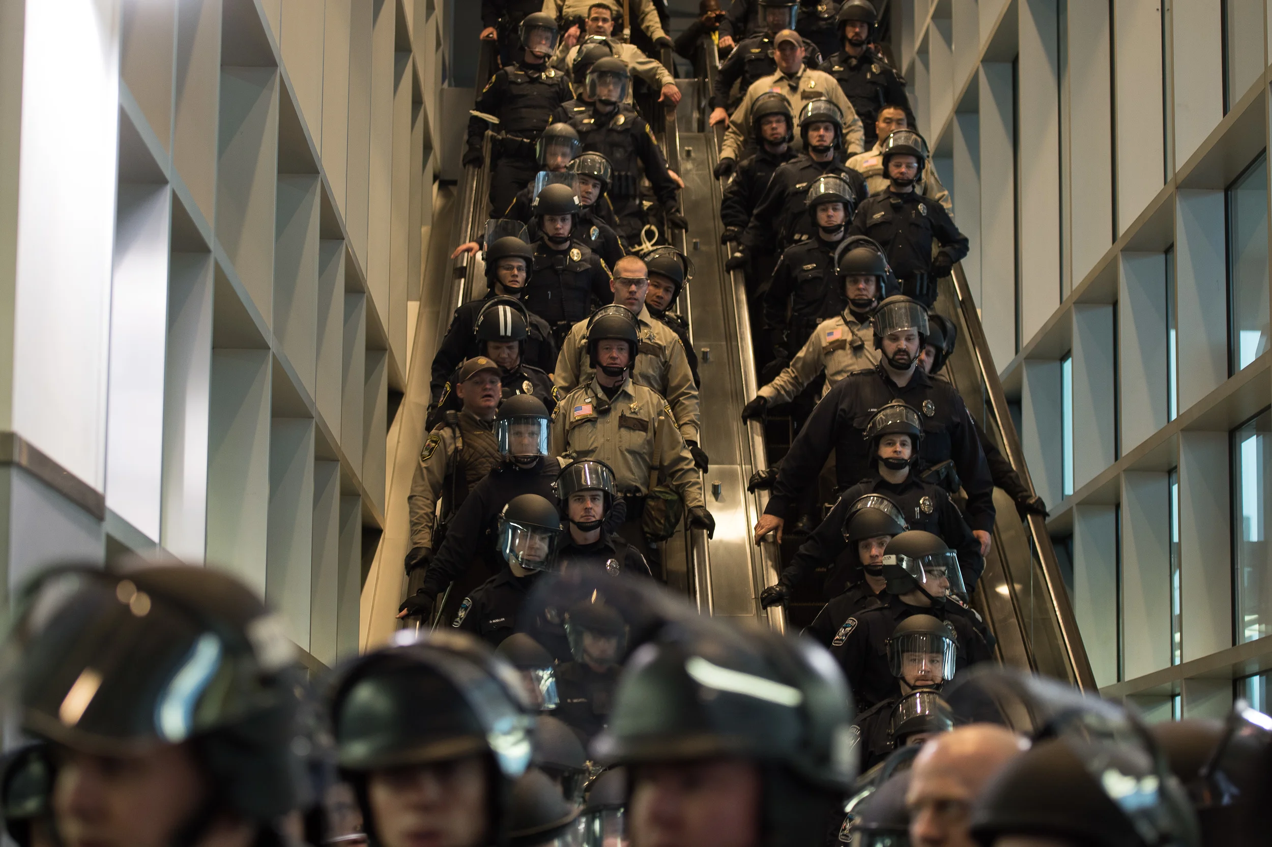 Police from the MSP airport, Richfield, Bloomington, Burnsville, Eagan and South St. Paul police departments push a group of protesters back onto the light rail plaform at MSP airport. December, 2015. For Minnesota Public Radio.