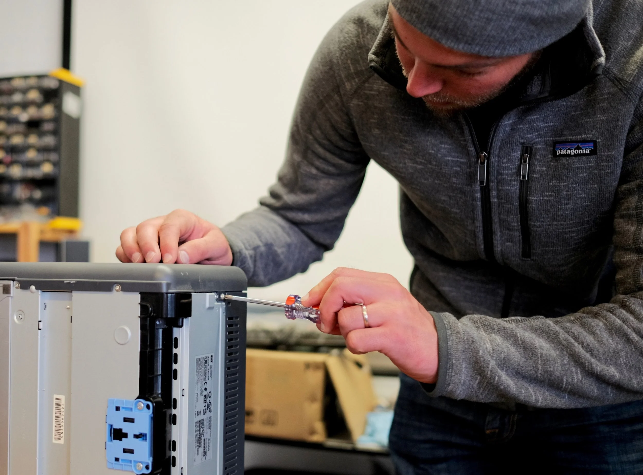 Chris Brandt of BAN's EarthEye program installing a tracker in a printer. Chris recently spent two days in Austin, installing EarthEye trackers for Dell Computers. Copyright BAN.