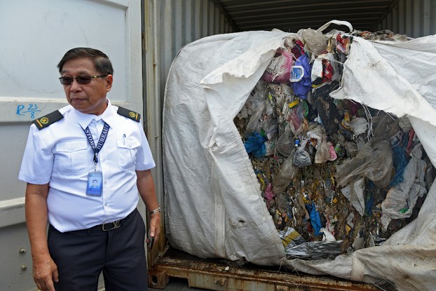 A customs official opens one of dozens of container vans filled with household waste at a port in Tagoloan, the southern Philippines province of Misamis Oriental, Jan. 13, 2019.