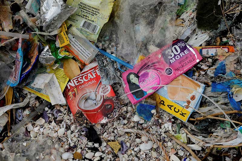 Sachets of Nestle's Nescafe coffee and Unilever's Sunsilk shampoo are pictured amidst a garbage-filled shore on Freedom Island, Paranaque City, Metro Manila, Philippines, July 15, 2019. Picture taken July 15, 2019. REUTERS/Eloisa Lopez