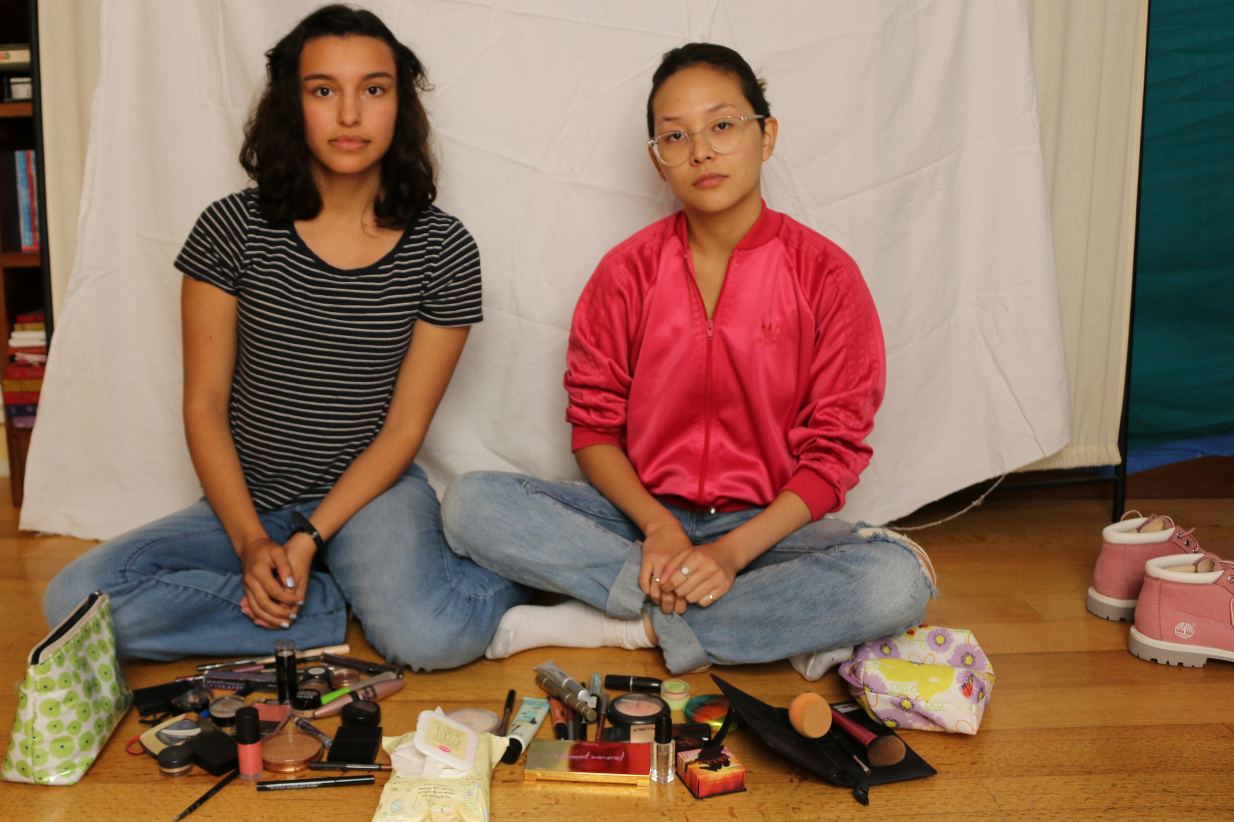 Tatiana (left) and Sara (right) with the piles of makeup from their daily routines.