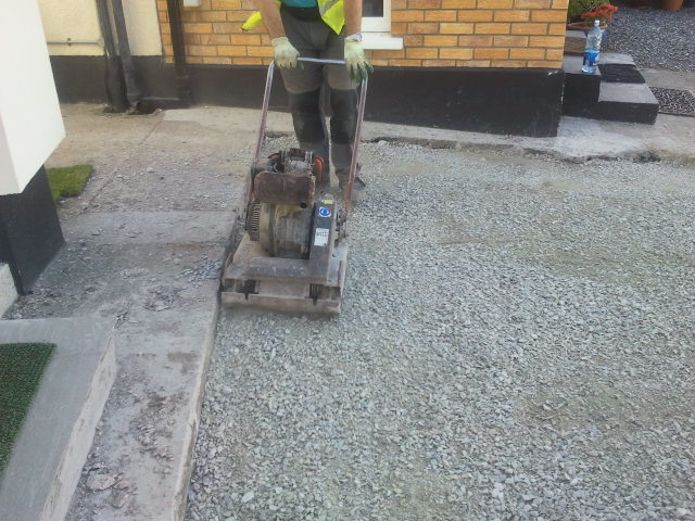 landscaper compacting driveway