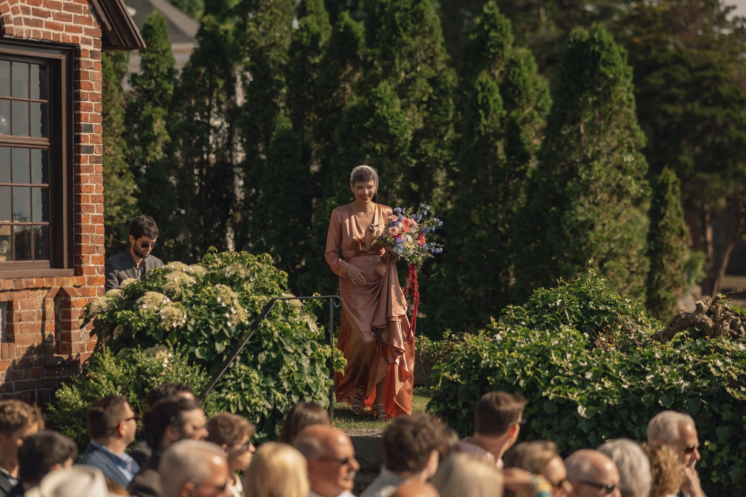 Documentary wedding photographer in America captures bride walking down the aisle at Beauport, the Sleeper-McCann House.