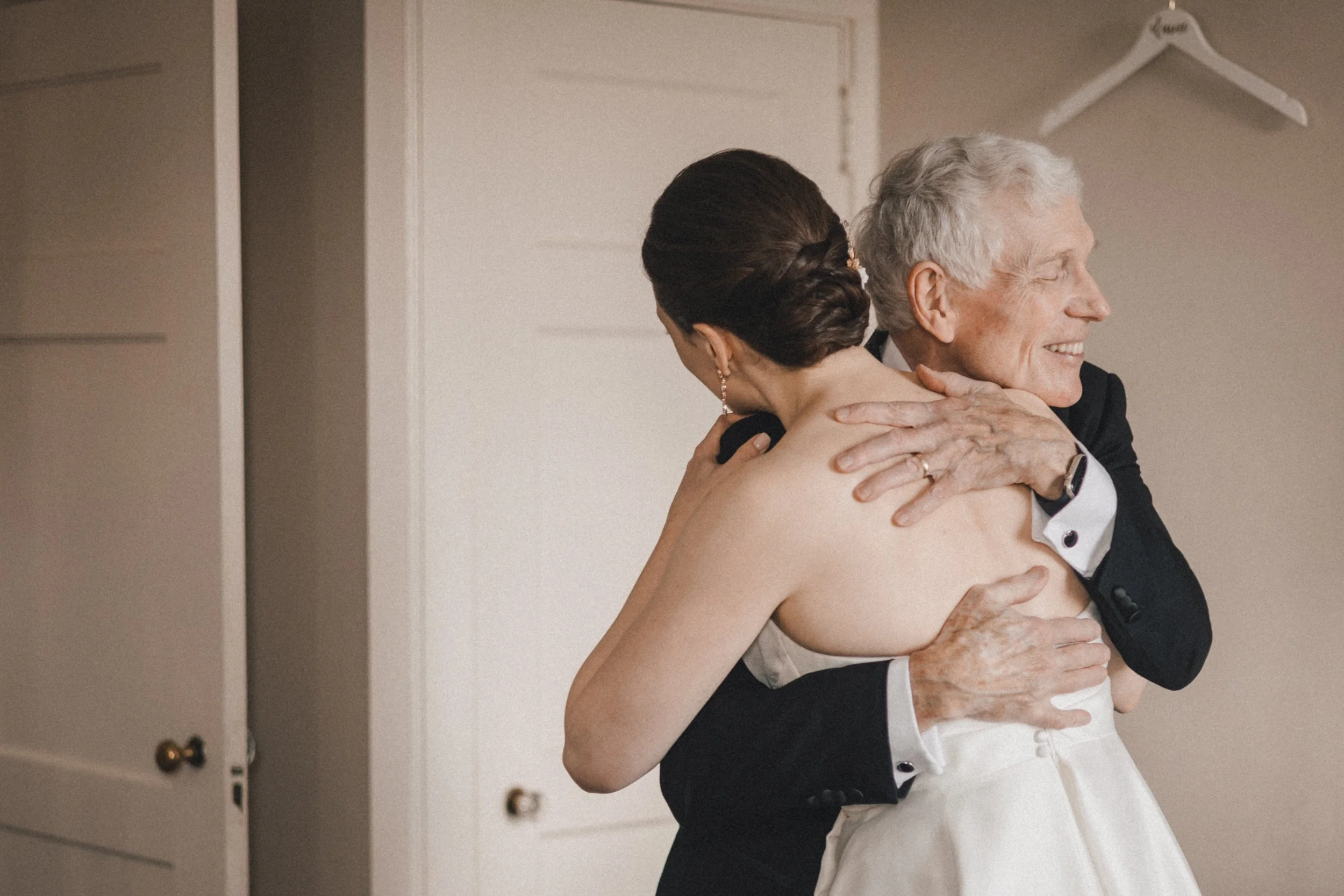 Father of the bride hugs daughter before Peabody Essex Museum wedding ceremony