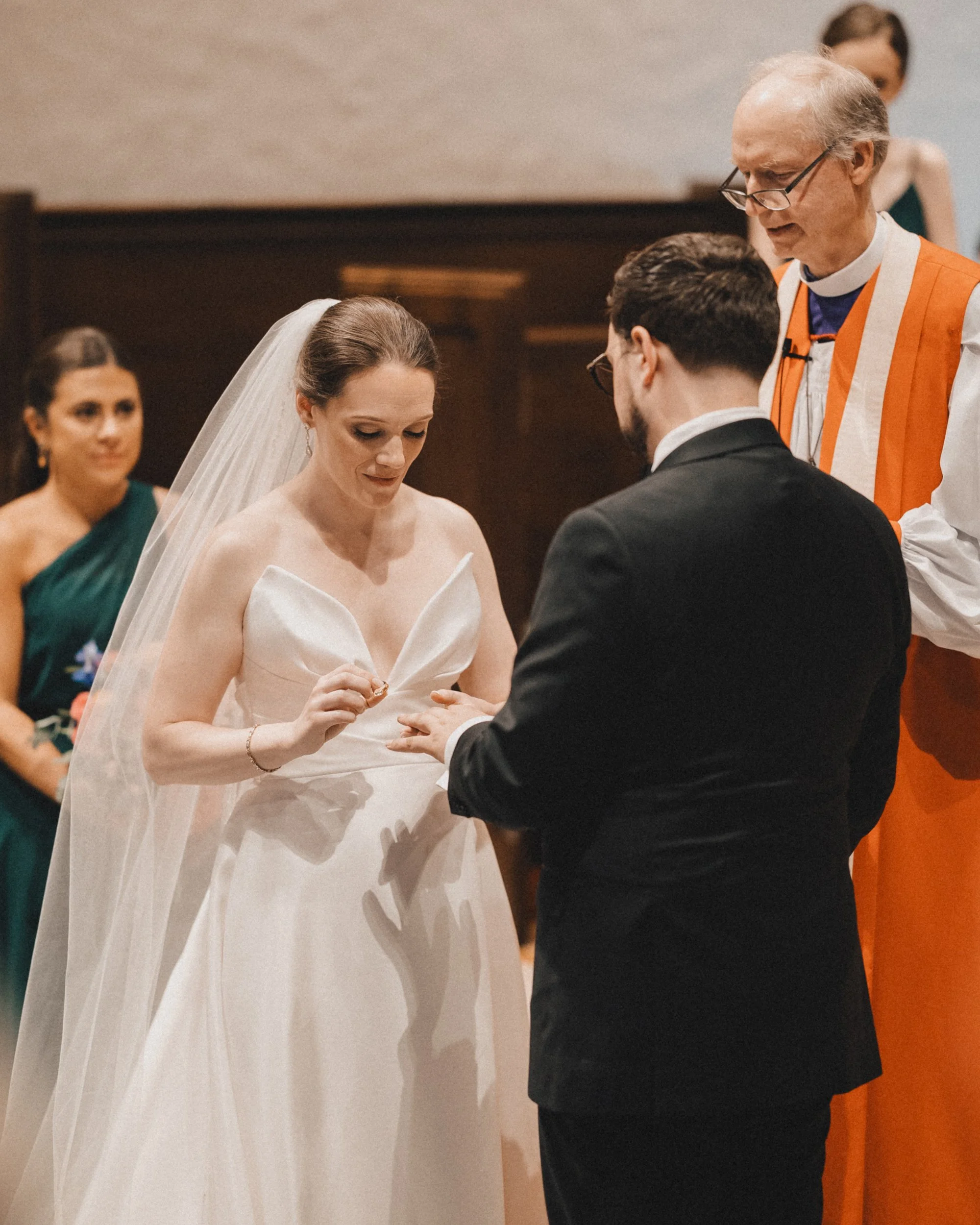 Bride placing ring on groom at Peabody Essex Museum wedding ceremony.