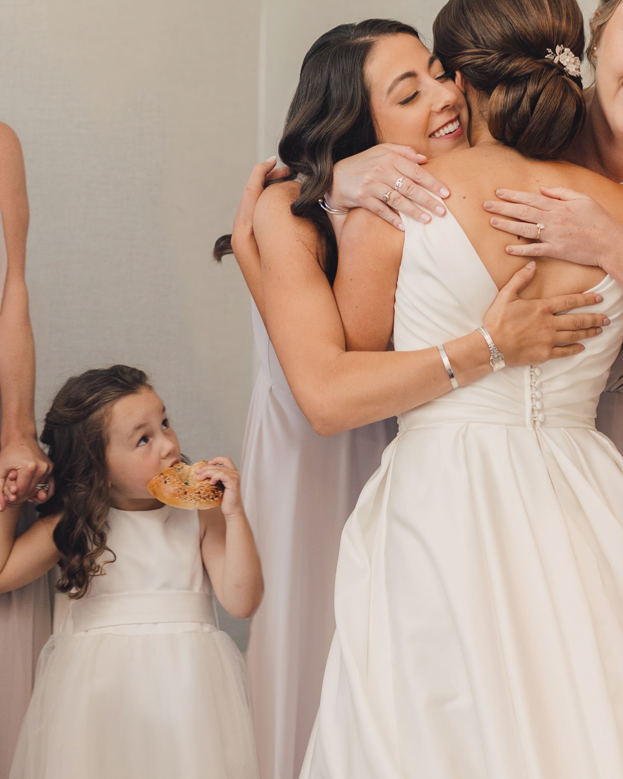 the flower girl eating a bagel before a sarasota wedding ceremony.