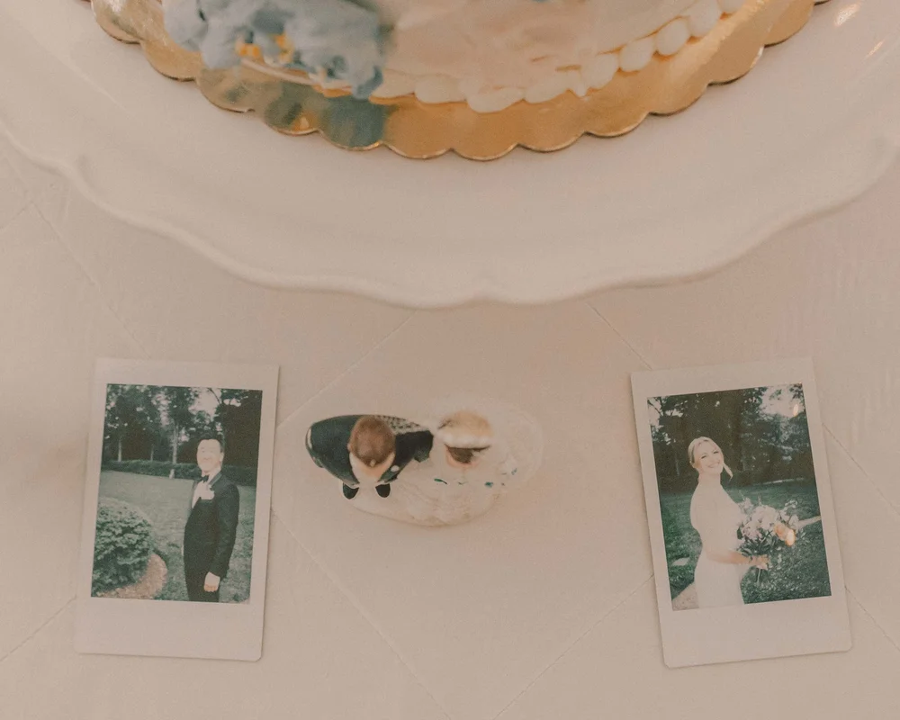 Instant guest prints arranged on the table beside the wedding cake