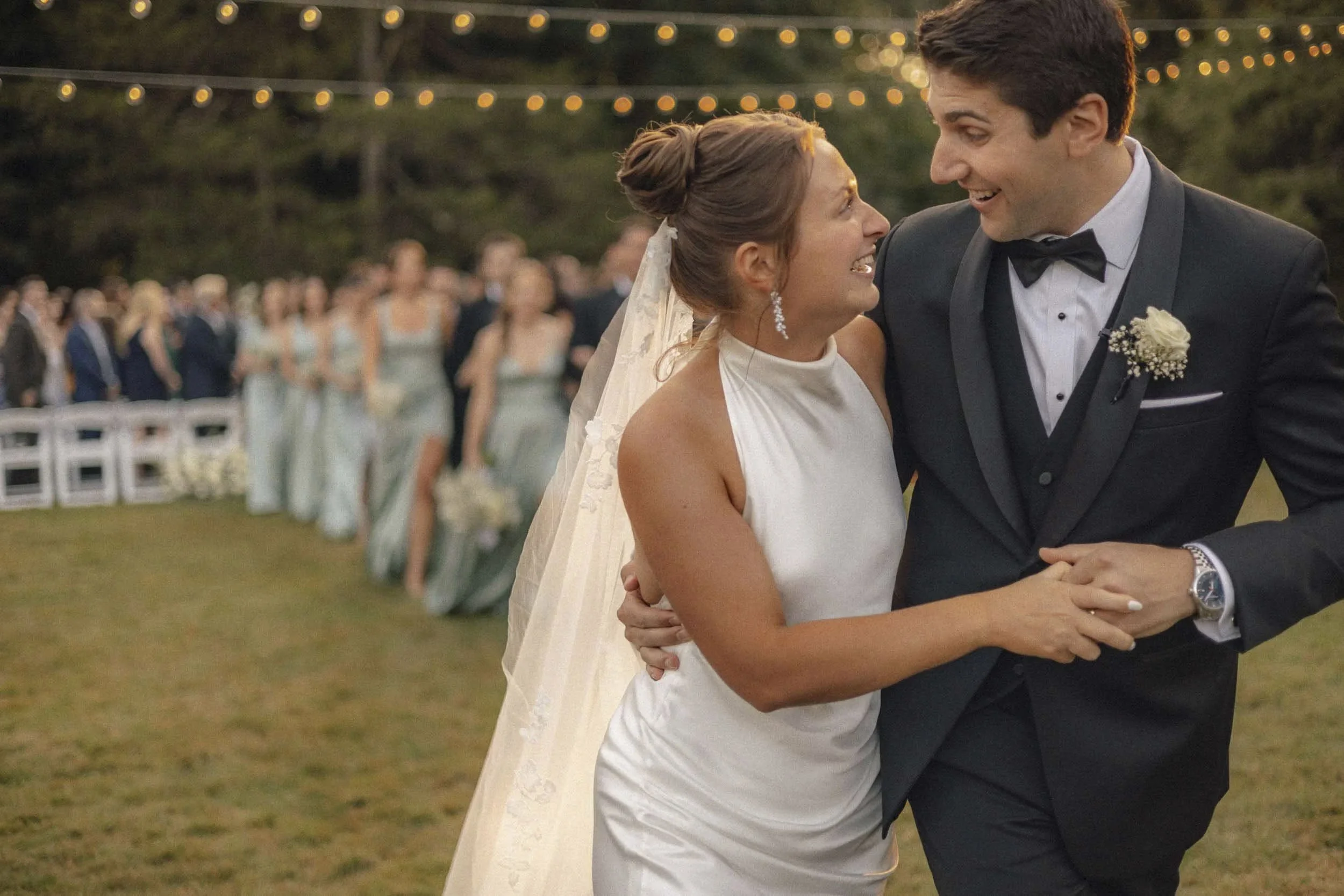 Couple walking under string lights — Sarasota documentary wedding photographer