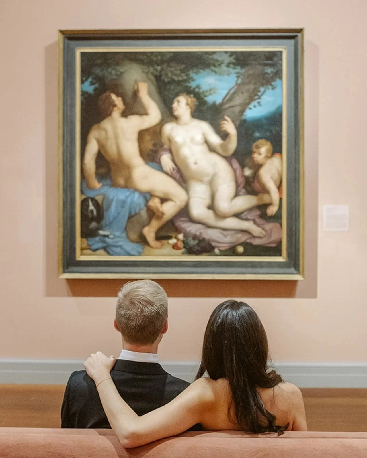Bride and groom sitting together on a bench admiring a Renaissance painting at The Ringling Museum in Sarasota.