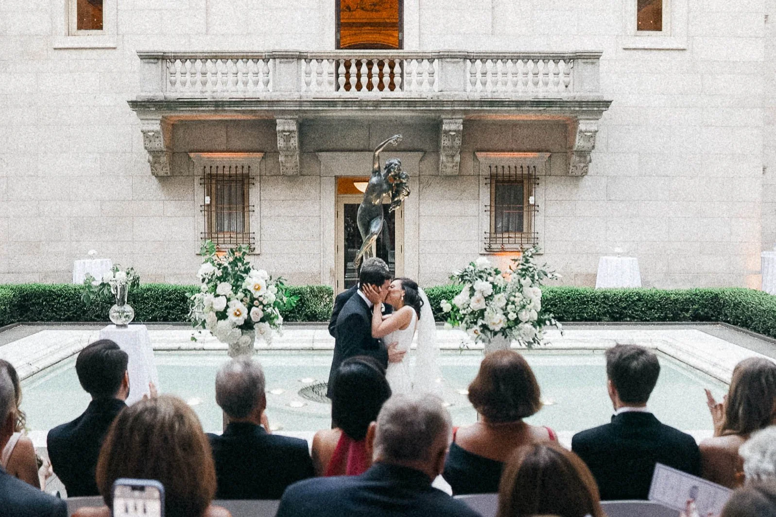 Bride and groom kiss by the Bacchante fountain at Boston Public Library wedding ceremony