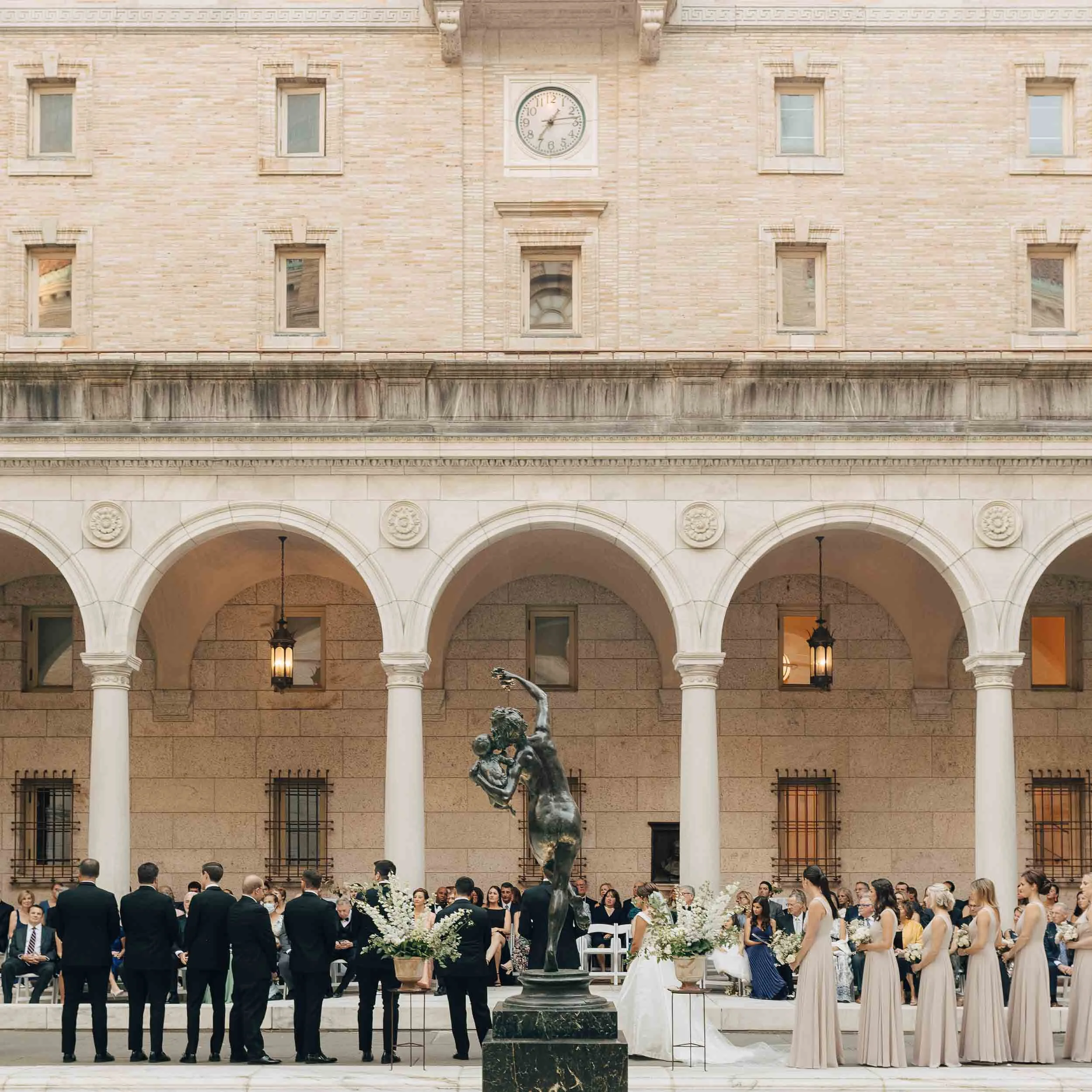 Wedding ceremony in BPL courtyard framed by arches and Bacchante fountain.