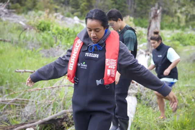 Student in PTE waders walking on log.jpg