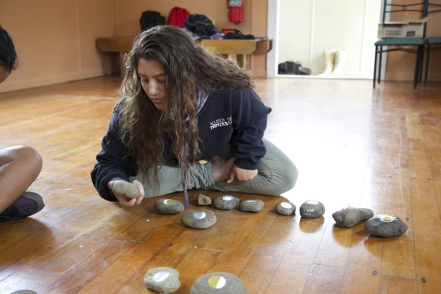 Student with phase of moon on pebbles.jpg