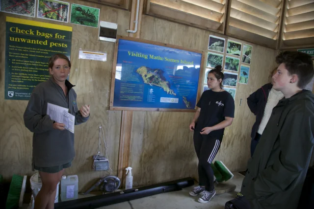 Students checking their belongings to ensure they are free of invasive species and materials like mice and seeds while visiting Matiu Somes Island.