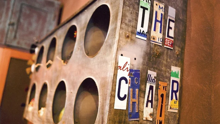 Wall of license plates spelling The Chair