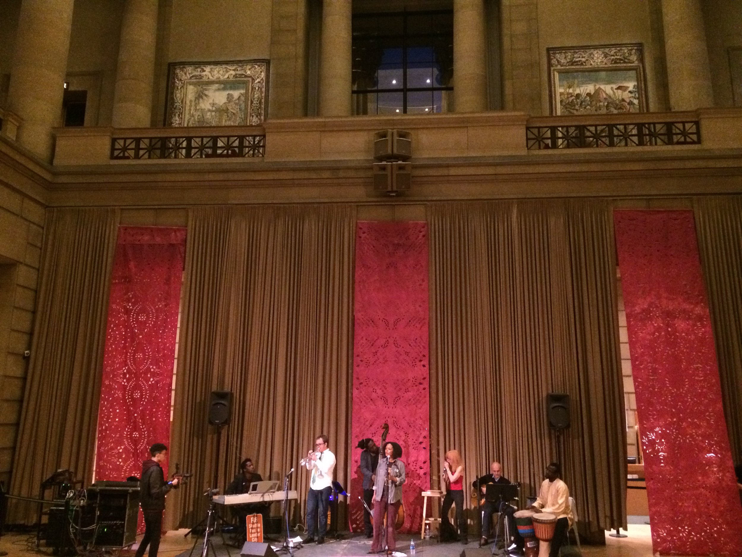 Yolanda Wisher and The Afroeaters perform at City of Poetry in front of a Karina Puente hand-cut backdrop. Photo by Karina Puente. 