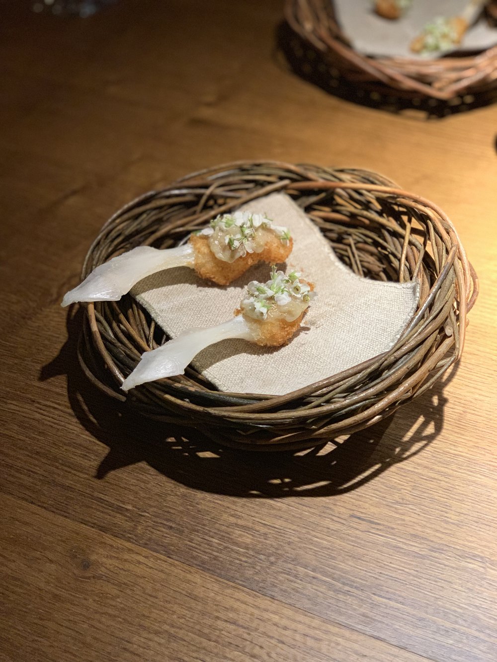  Cod tongue schnitzel coated in sourdough and fried with green strawberry and wasabi flowers from Iceland. The cod’s tongue is attached to two jaw bones, so each of us received one side of the tongue still attached to the bone. 