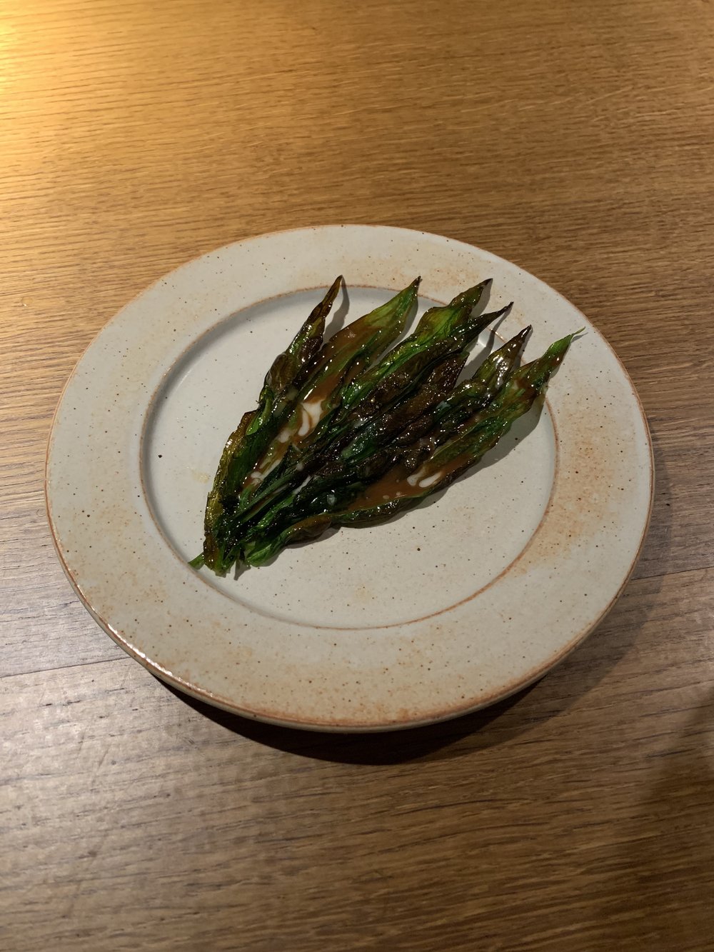  Grilled, wild ramson shoots. Picked from the forest, cleaned, and grilled outside. Finished with a paste of clams. 