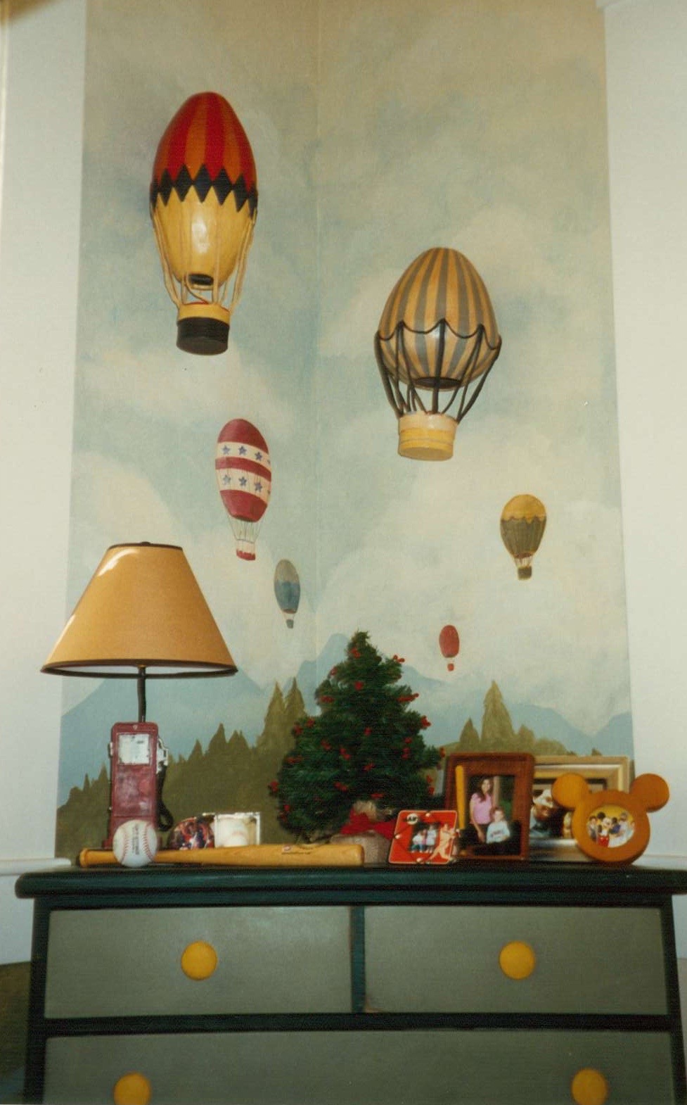 A muted landscape with hot air balloons is the background for this owners collection of tin hot air balloons.