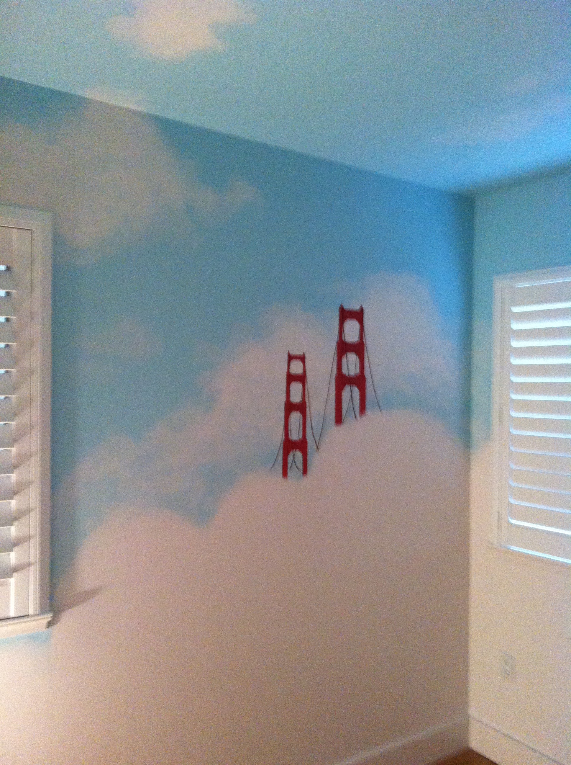 A San Francisco themed nursery, clouds and fog cover both ceiling and walls, to create a peaceful resting space.