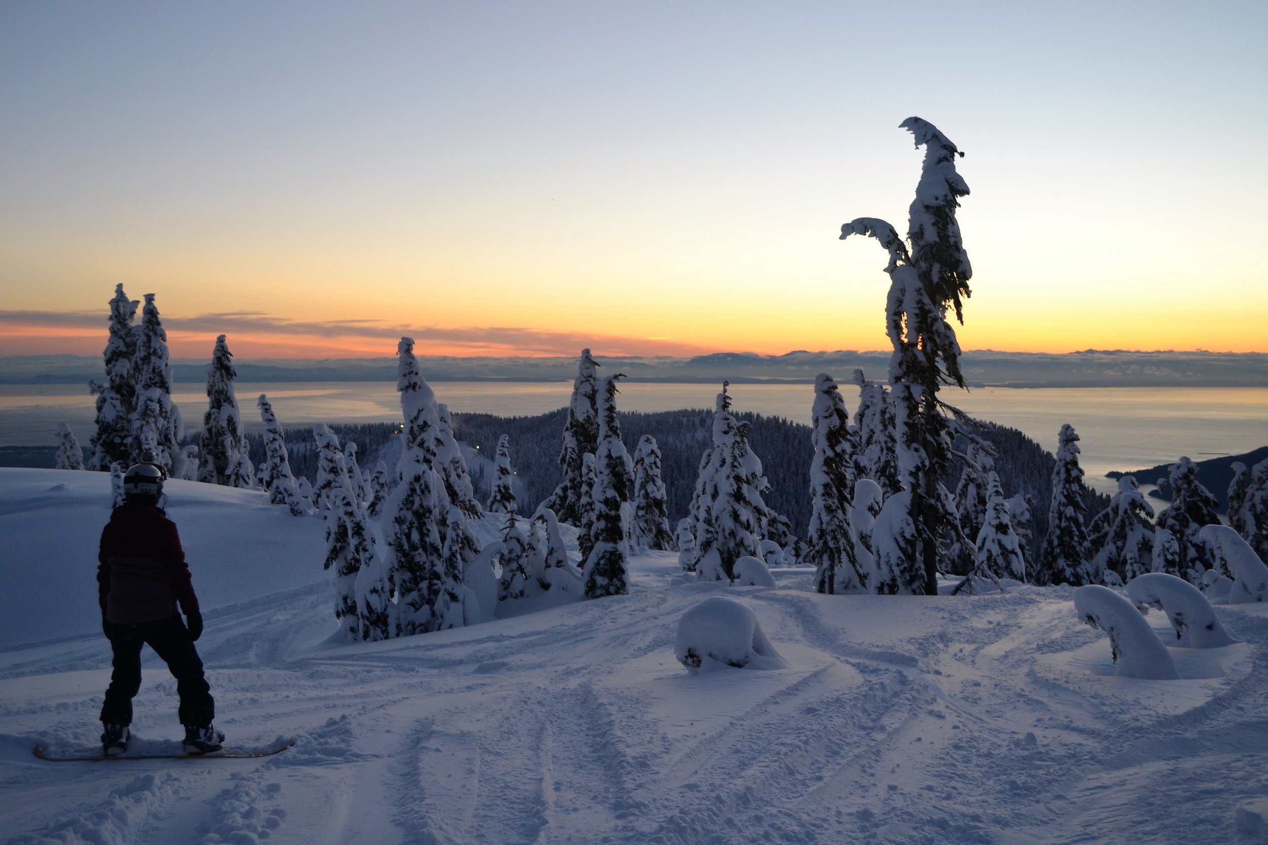 Snowboarder overlooking the ocean in Vancouver during sunset
