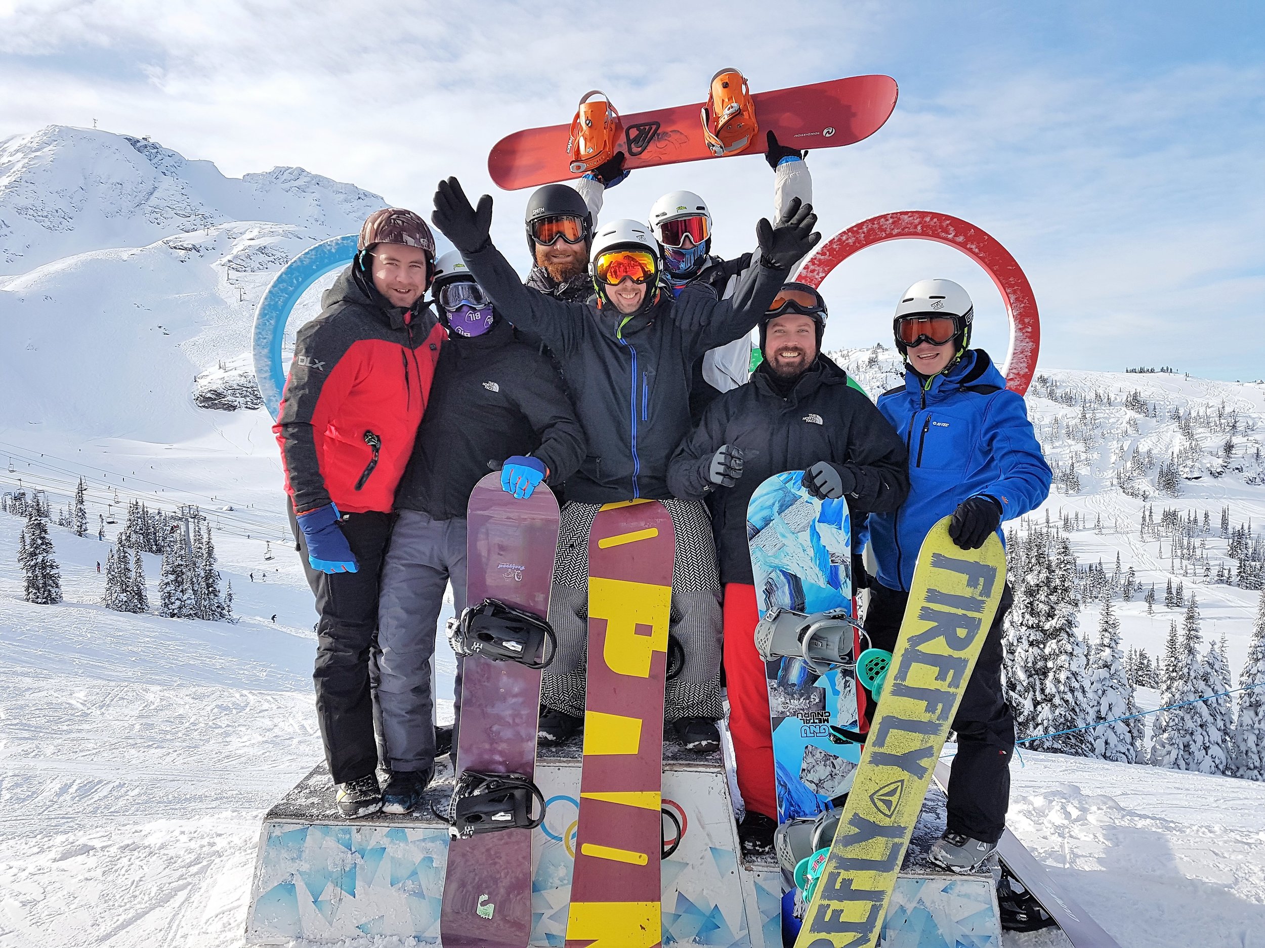 Group photo of snowboarders infront of the logo of the Olympic Games of 2010