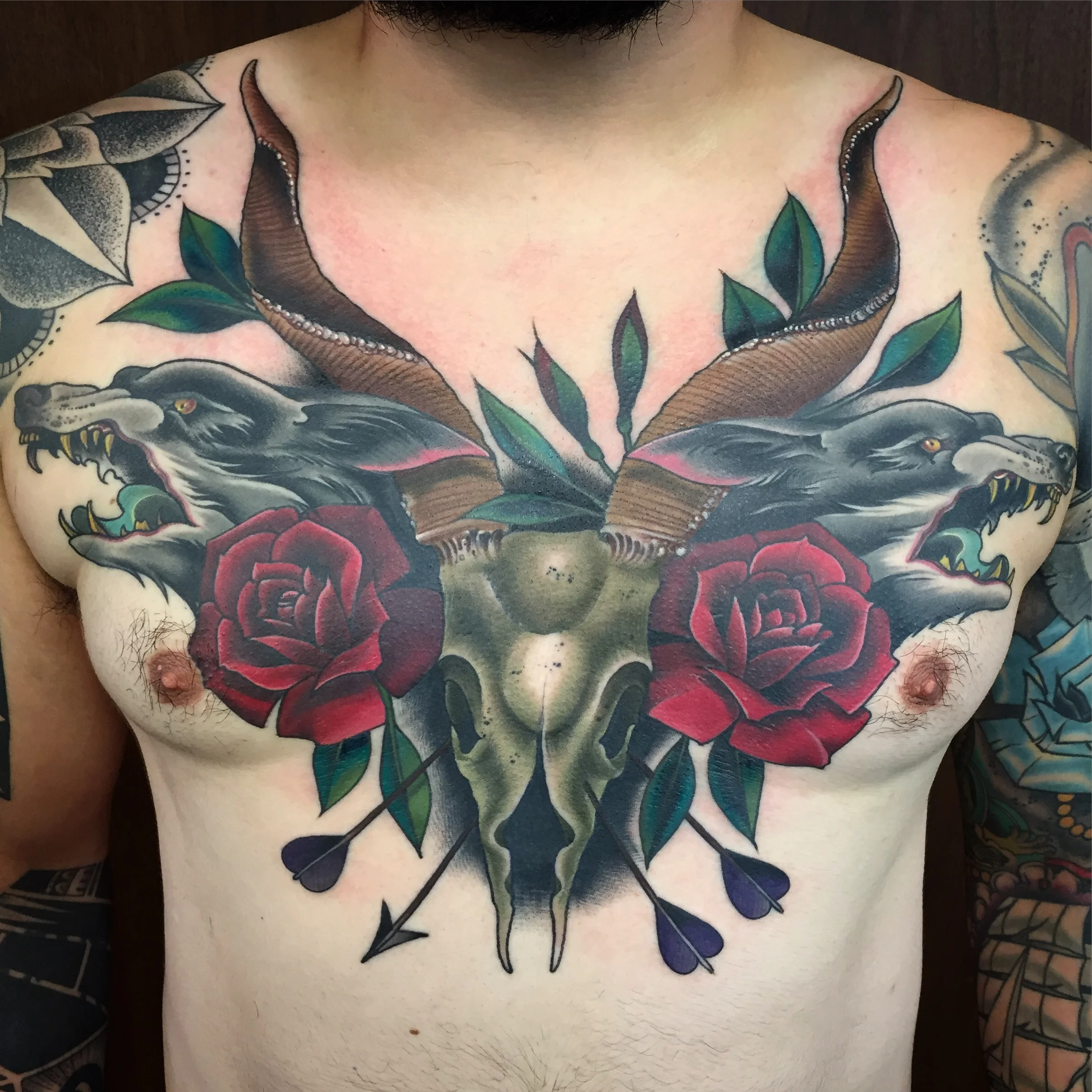 goat skull and wolfs with roses chest piece.