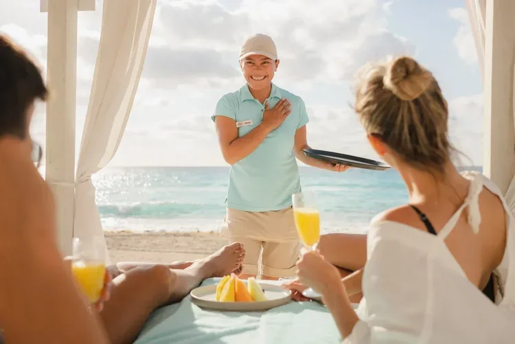 Hotel waiter serving breakfast to guests on the beach, staff portrait photography by David McConaghy
