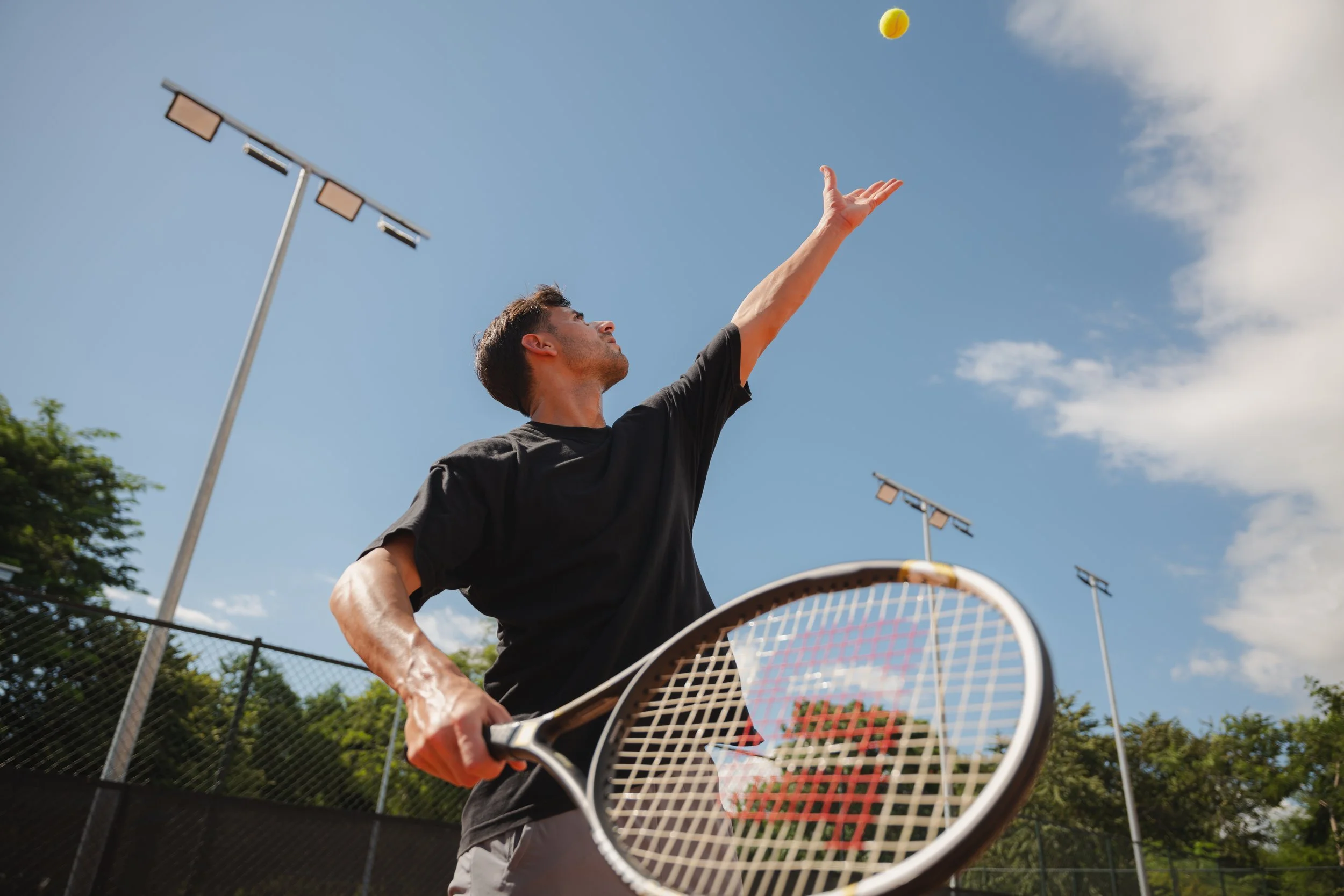 Guest serving at tennis court at luxury Caribbean resort, David McConaghy Photography