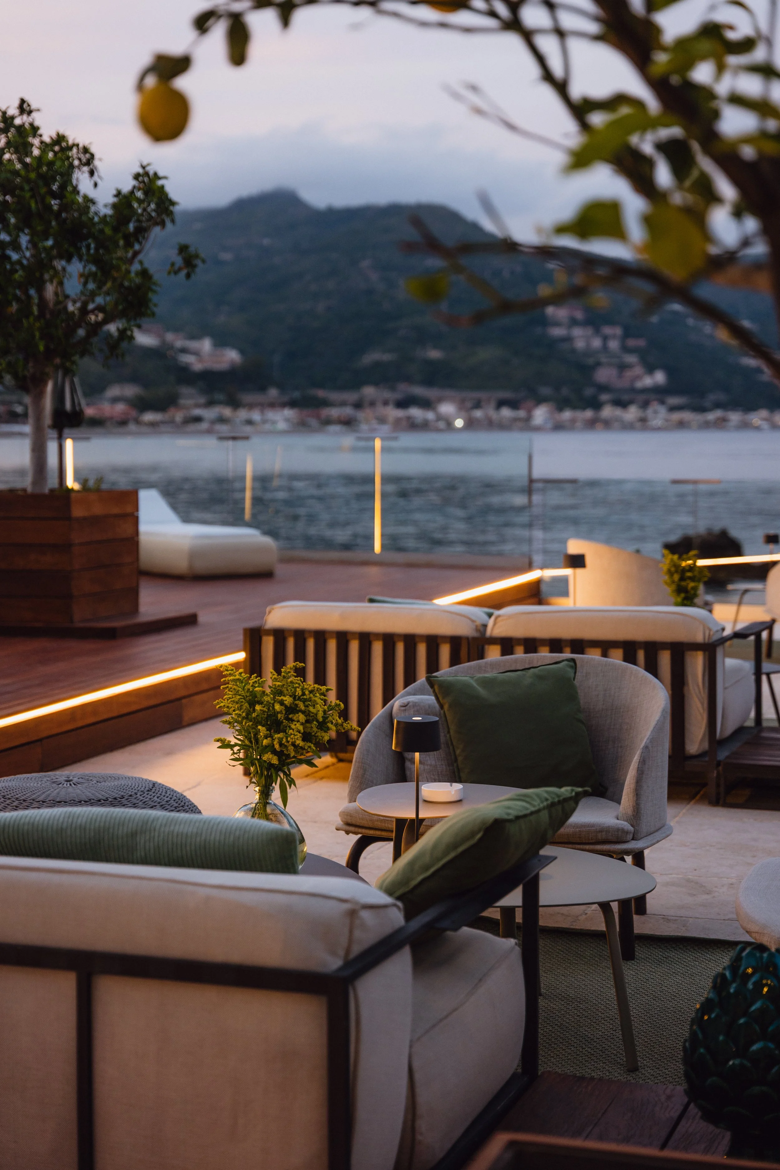 Luxury hotel terrace lounge with waterfront and mountain views at dusk, David McConaghy Photography