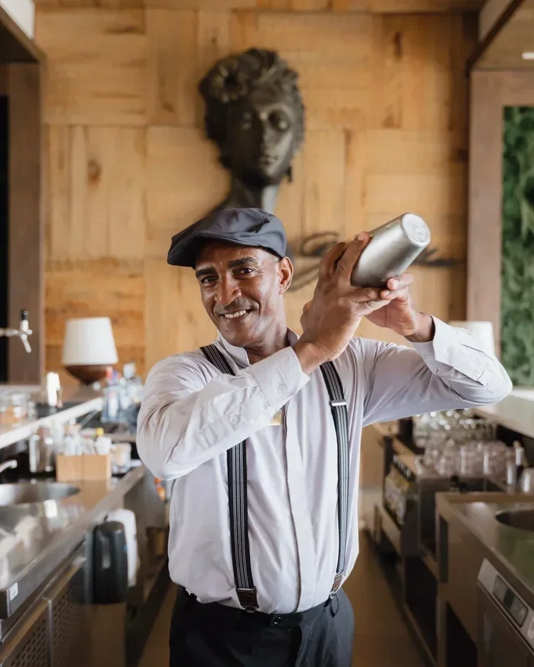 Hotel bartender shaking cocktail at luxury resort bar, staff portrait photography by David McConaghy