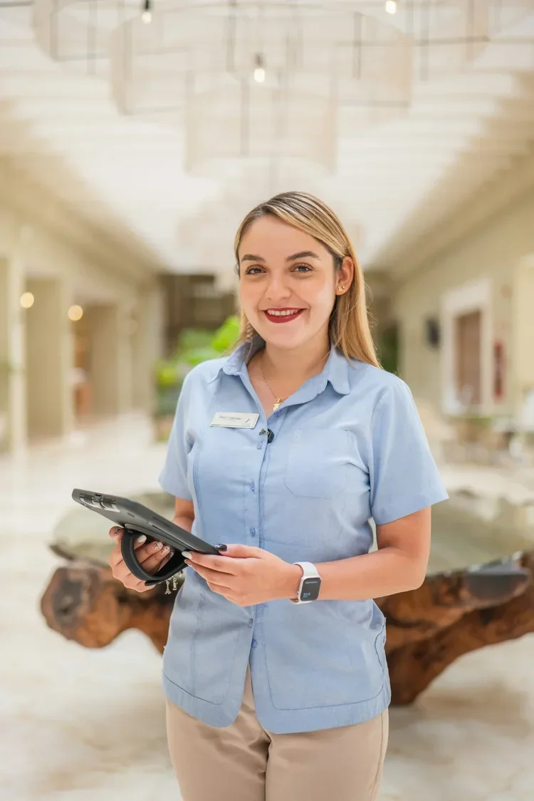 Hotel guest services staff member with tablet in corridor, staff portrait photography by David McConaghy
