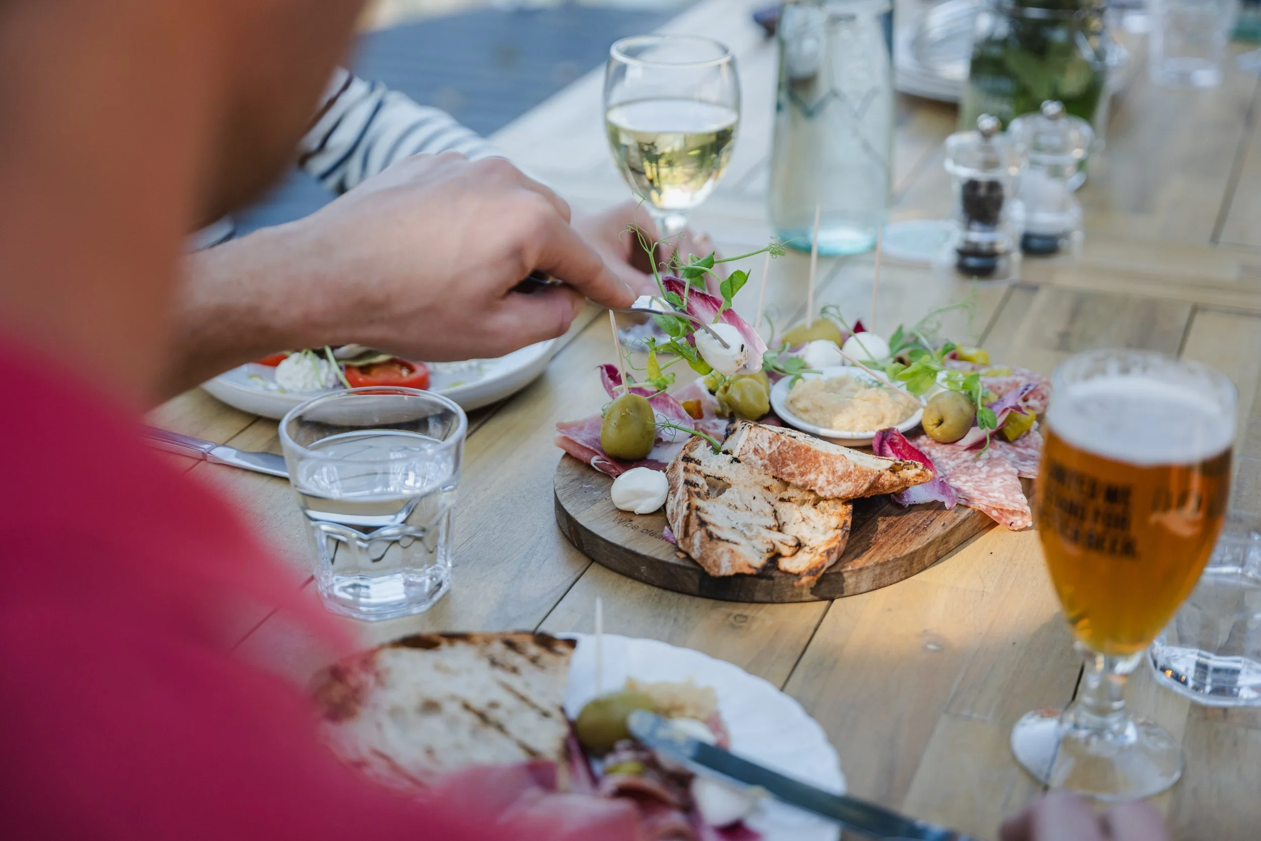 Guests sharing fine dining dishes with wine at luxury hotel, F&B photography by David McConaghy