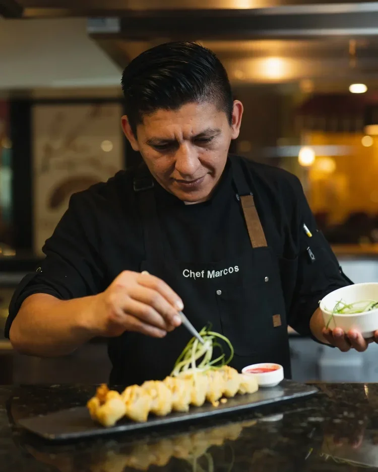 Hotel head chef plating fine dining dish in kitchen, staff portrait photography by David McConaghy

