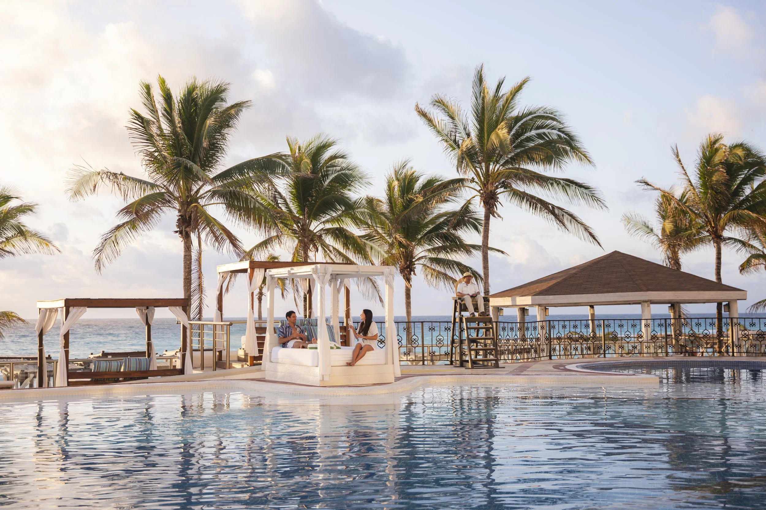 Infinity pool at sunset with palm trees at luxury Caribbean resort, David McConaghy Photography