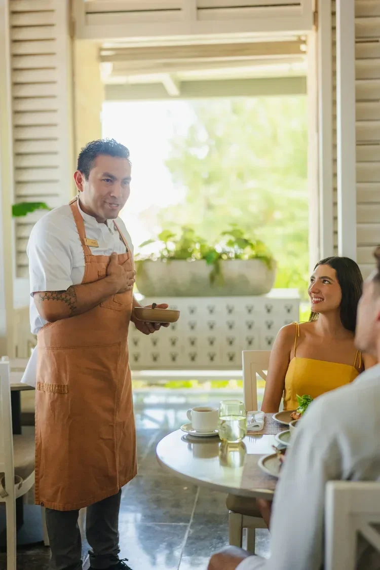 Hotel restaurant chef engaging with guests at table, staff photography by David McConaghy