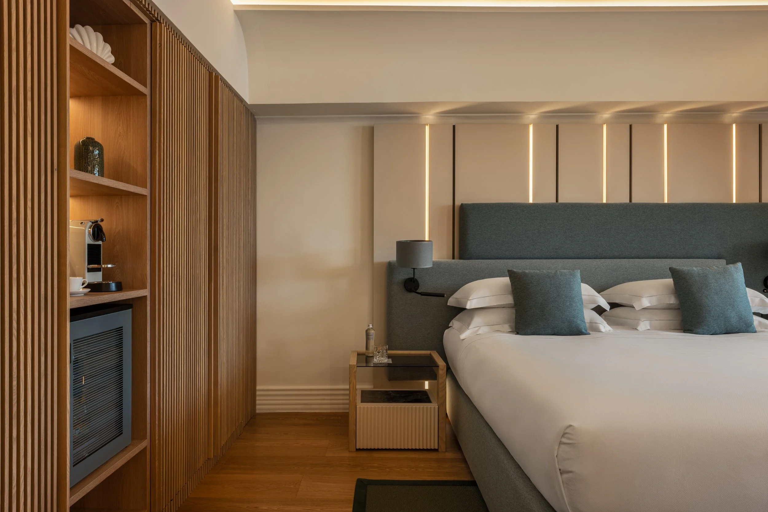 Luxury hotel bedroom with upholstered headboard and mood lighting, David McConaghy Photography
