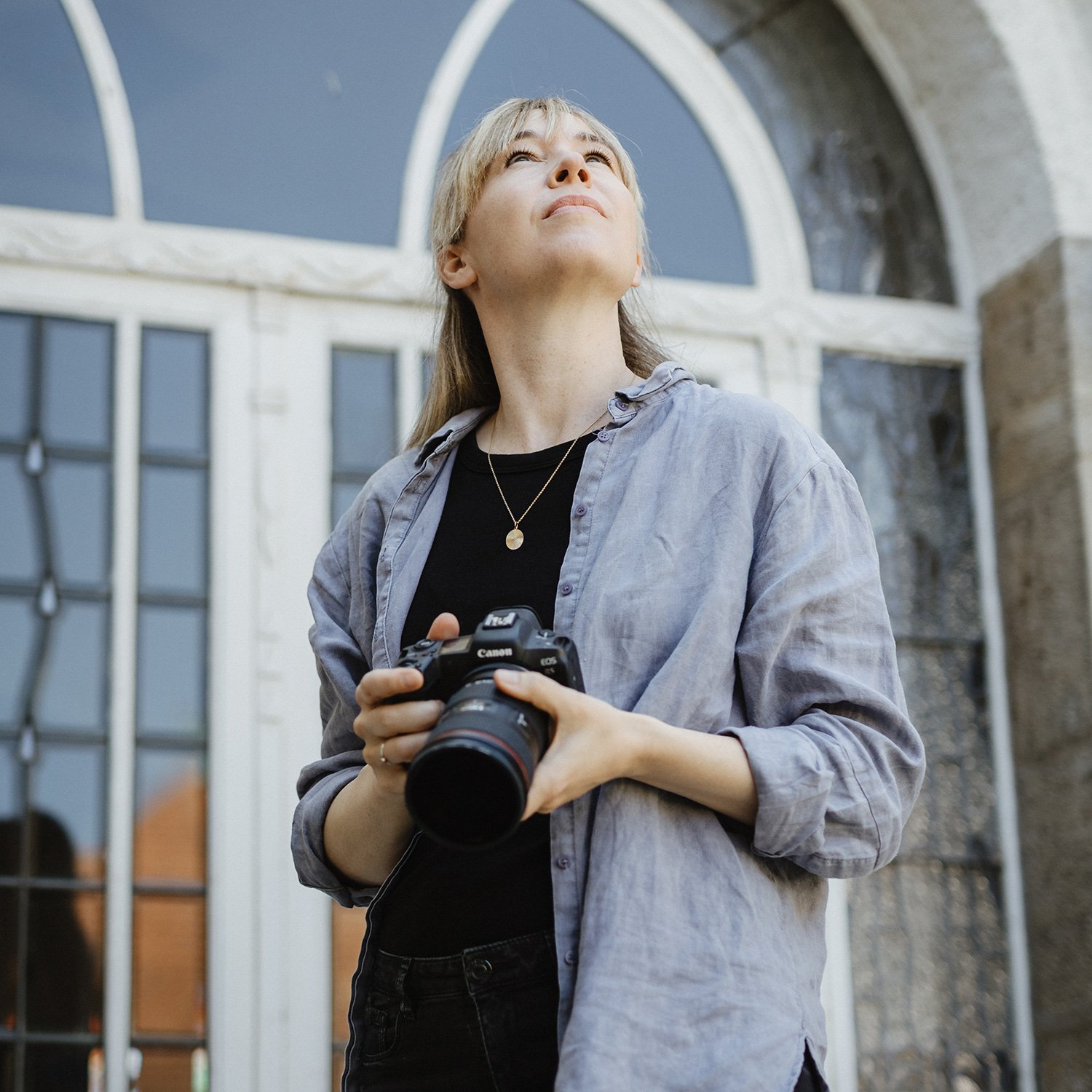 Mareike Böhmer Photography Portrait - artist holding a Canon camera looking into the sky