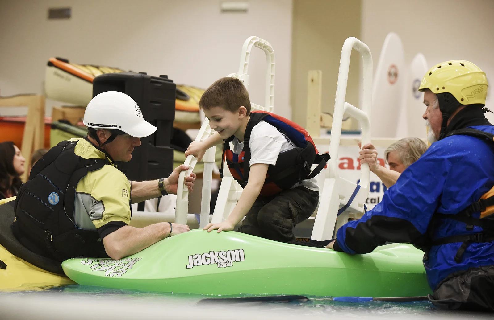 ERICA MILLER / GAZETTE PHOTOGRAPHER In excitement Abel Whitbeck, 5-years-old of Saratoga, makes it into a kayak with the help from Jason LaSelva with the Sacandaga Outdoor Center (left), and NYS Director for the American Canoe Association Mike Cavanaugh, of Vooresville, during the Adirondack Sports Summer Expo at the Saratoga Springs City Center on Saturday afternoon, March 18, 2017.