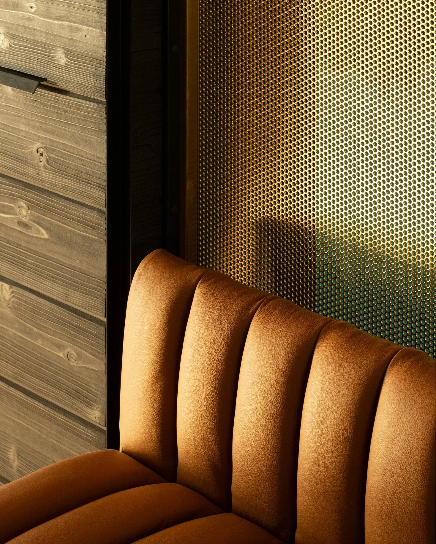 We want you to experience 100 moments of care at your home every day.  That's the purpose behind the effort we put into small transitions like this where a leather bench meets a perforated brass guard and charred cypress siding.  The play of light an